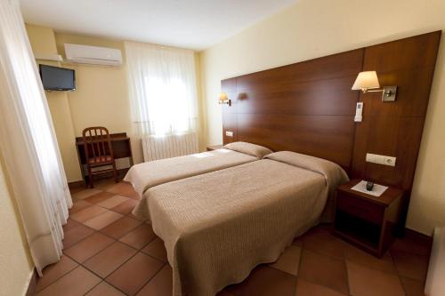 Postel nebo postele na pokoji v ubytování Hostal Restaurante Santa Cruz