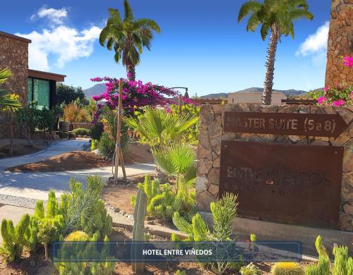 a sign for the desert suite at a hotel with palm trees at Entre Viñedos by Hotel Boutique Valle de Guadalupe in Valle de Guadalupe