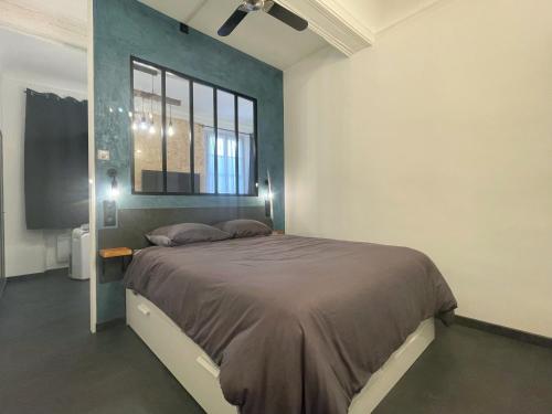 Un dormitorio con una cama grande y una ventana en L'Atelier de l'Amiral - Parking - Centre Historique en Grasse
