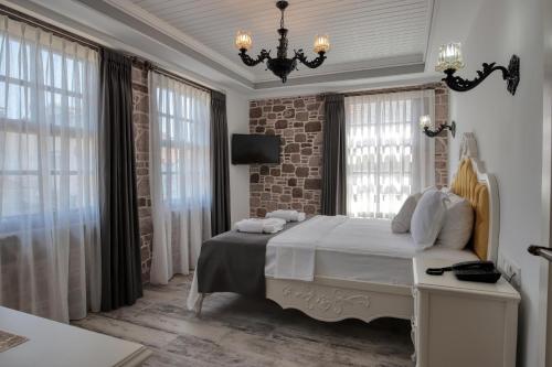 Schlafzimmer mit einem Bett, einem Kronleuchter und Fenstern in der Unterkunft Cunda Taka in Ayvalık