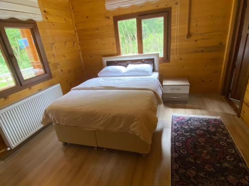 a bedroom with a bed in a log cabin at New toprak suite in Uzungöl