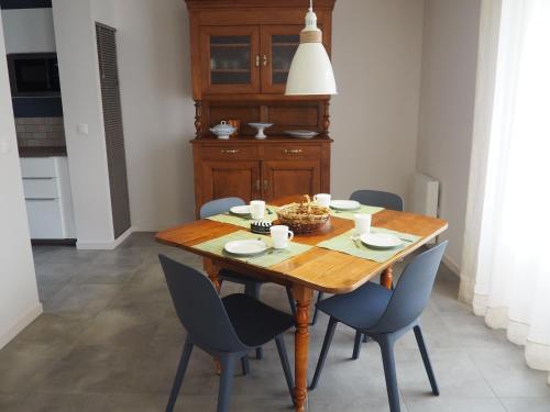 une salle à manger avec une table et des chaises en bois dans l'établissement La Longère, à Lamballe