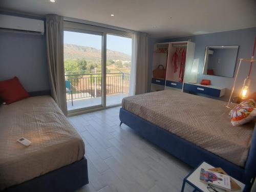 ein Hotelzimmer mit 2 Betten und einem Balkon in der Unterkunft Stella-Guesthouse in Solarino