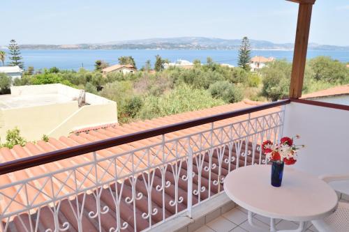a balcony with a table and a view of the water at Tzivras Villa & Apartments in Lassi
