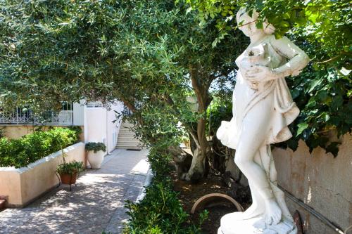 a statue of a woman standing next to a sidewalk at Tzivras Villa & Apartments in Lassi