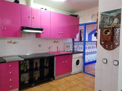 cocina con armarios rosados y lavadora en CASALINDA en Almagro