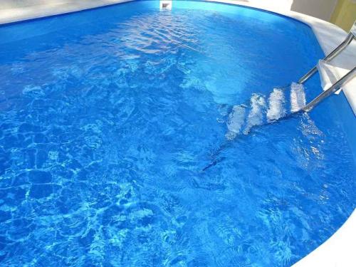 a pool filled with blue water with water bottles at Apartment in Dramalj 5744 in Dramalj