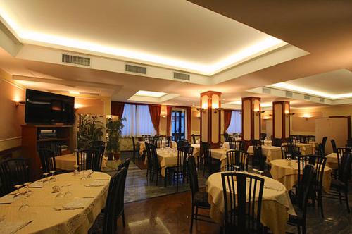 um restaurante com mesas e cadeiras com toalhas de mesa brancas em Albergo Ristorante Val Vomano em Penna SantʼAndrea