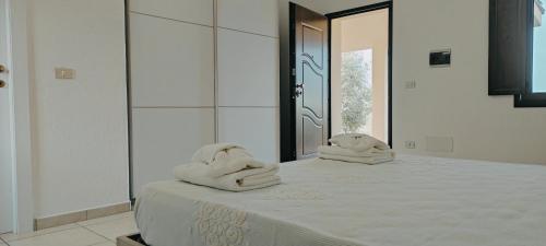dwa ręczniki siedzące na łóżku w pokoju w obiekcie Sa Teria Village - Camere Deluxe - w mieście Tertenìa