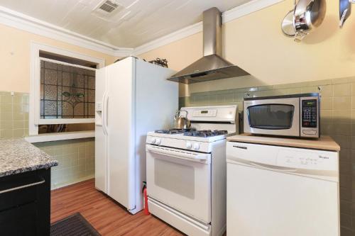 a kitchen with a stove and a microwave at Historic Inn in the Marigny, blocks to French Quarter in New Orleans
