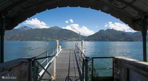 a dock with a view of the water and mountains at CasaCamelia 35, 3 BDRM with view Lake Como in Acquaseria