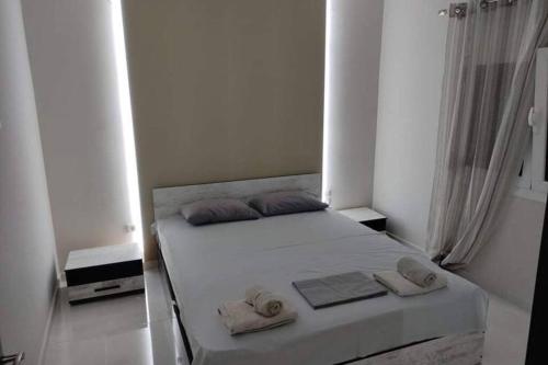 a white bedroom with a bed with towels on it at Kilkis Paradise in Kilkís
