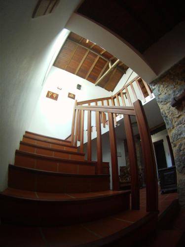 a spiral staircase in a building with a stone wall at Casa de Guadalupe in Redouça