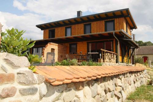 ein Haus mit einer Steinmauer davor in der Unterkunft Holiday home in Friedland 2712 in Kummerow