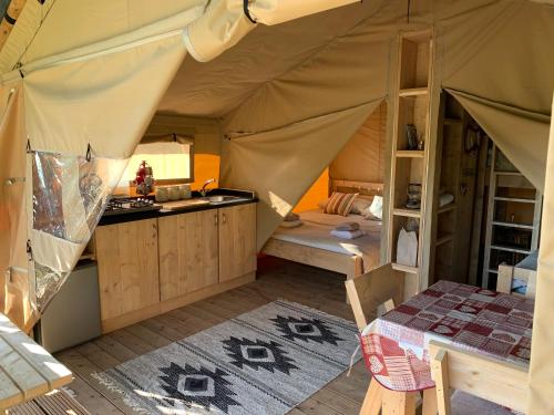 a tent with a kitchen and a table in it at Safari Tent with Hot Tub in heart of Snowdonia in Dolgellau