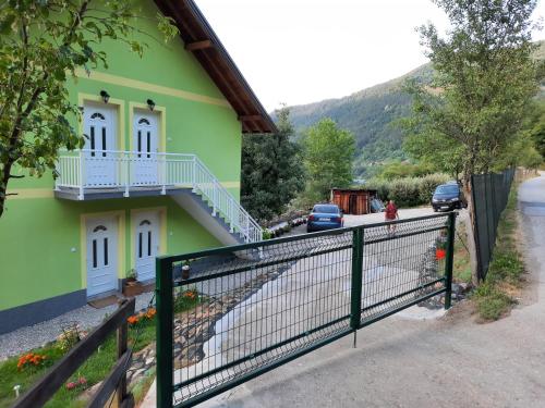 a green house with a fence in front of it at Apartmani Vila na Drini in Foča