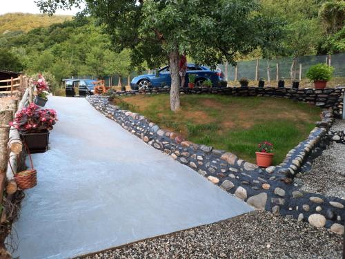 a walkway with rocks and a tree in a yard at Apartmani Vila na Drini in Foča