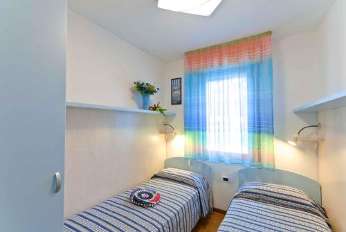 ビビオーネにあるApartment in Bibione 24432のベッドルーム1室(ベッド2台、窓付)