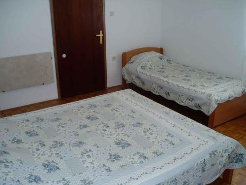 2 bedden in een kleine kamer met een sprei bij Two-Bedroom Apartment in Senj I in Nehaj