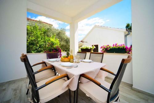 Biały stół i krzesła na patio z oknem w obiekcie Two-Bedroom Apartment in Biograd na Moru II w Biogradzie na Moru