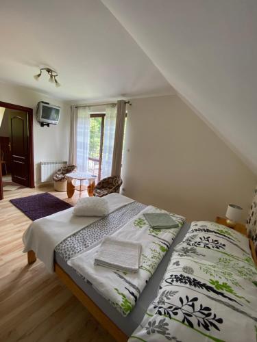 sypialnia z łóżkiem i oknem w obiekcie Miodowa Polana w Polańczyku