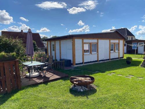 einen Hinterhof mit einem Haus mit einem Tisch und einem Picknicktisch in der Unterkunft Holiday home in Gustow/Insel Rügen 3077 in Gustow