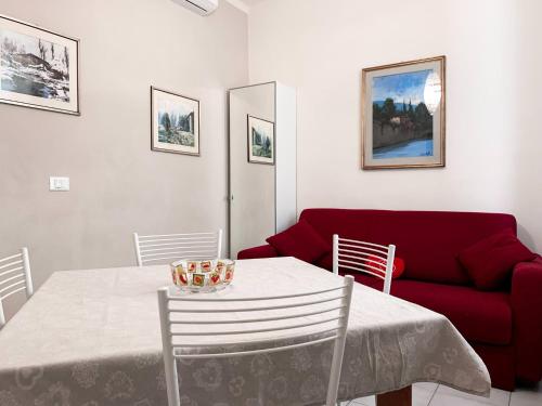 un soggiorno con tavolo e divano rosso di Nido Holiday Apartment Verona a Verona