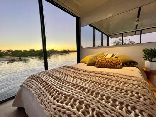 a bedroom with a large bed with a view of the water at oasis noosa - luxury floating eco villas in Noosa Heads