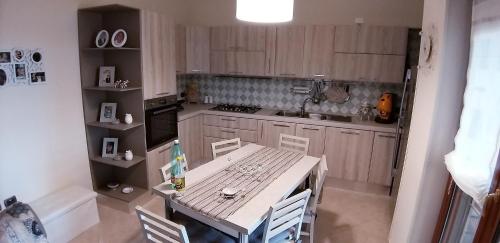 uma pequena cozinha com mesa e cadeiras em Appartamento Lungomare 20 mt dal mare em Crotone