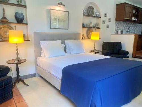 ポンタ・デルガダにあるCasa dos Agapantosのベッドルーム1室(青いシーツとランプ2つ付)