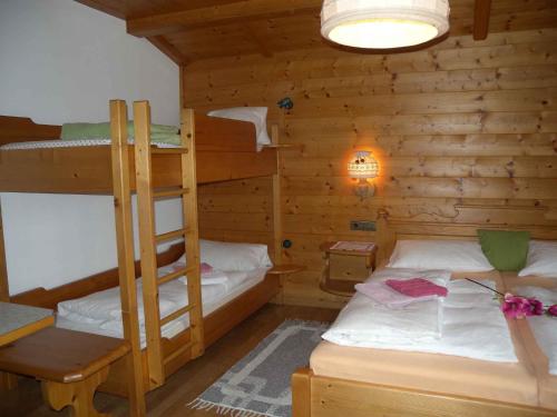 a bedroom with two bunk beds in a log cabin at Apartment in St. Johann in Tirol 555 in Alpendorf