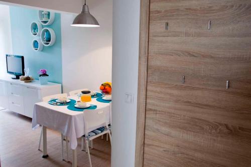 a dining room with a table and a wooden door at Apartment Vrbnik 6 in Vrbnik
