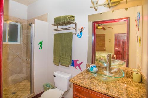 a bathroom with a sink and a toilet and a shower at Del Playa #3 Condo in West End