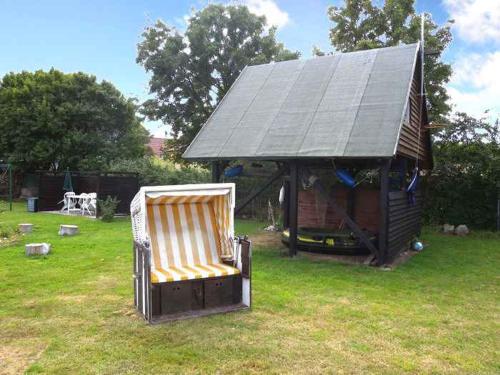 a chair in a yard next to a gazebo at Apartment Altenkirchen 4 in Altenkirchen