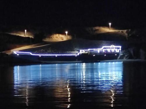 a boat with lights on the water at night at Big Blue - Xenija (Veliko Plavetnilo - Ksenija) in Metajna
