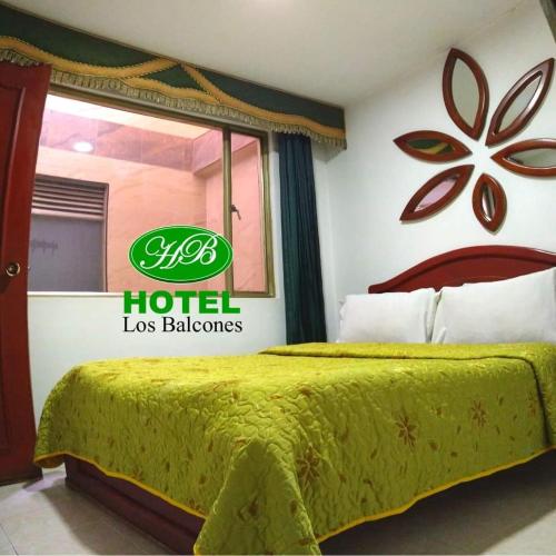 a hotel room with a bed with a sign on the wall at HOTEL LOS BALCONES in Bogotá