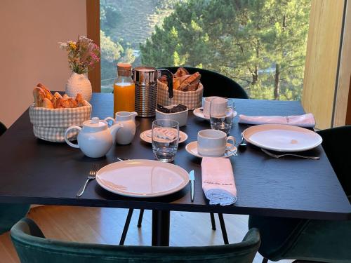 a blue table with plates and cups and food on it at Casa do Arco by Douro Exclusive in São Cristóvão do Douro