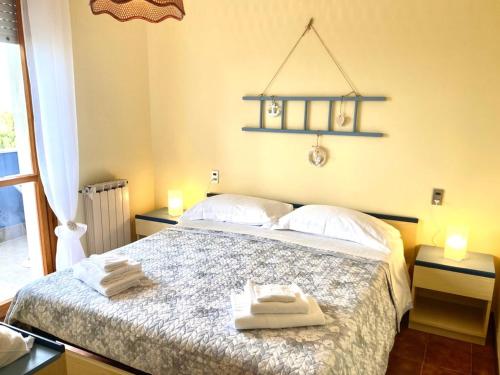 1 dormitorio con 1 cama con toallas en Temporary Home Silvi 3 en Silvi Marina
