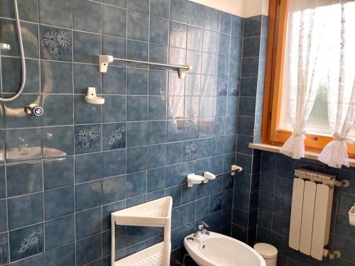 un bagno piastrellato blu con lavandino e WC di Temporary Home Silvi 3 a Silvi Marina