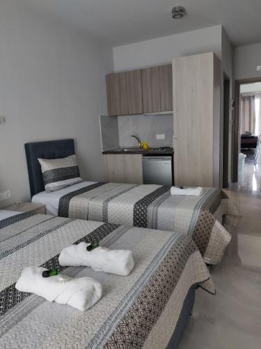 3 łóżka w pokoju z ręcznikami w obiekcie Mei's luxury apartments w Stavrós