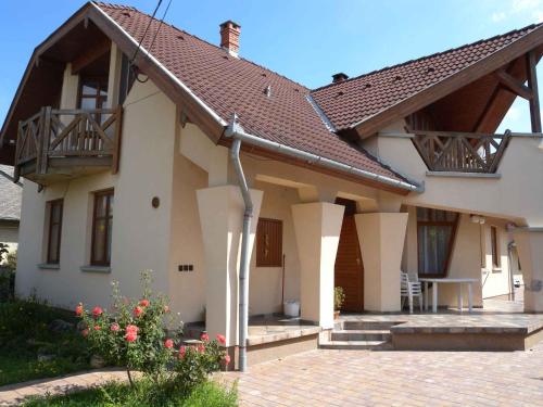 a white house with a roof and a patio at Apartment Balatonlelle 6 in Balatonlelle