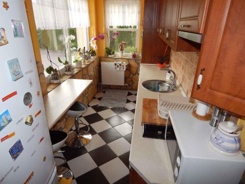 een keuken met een zwart-wit geruite vloer bij Holiday home Balatonfűzfo/Balaton 18798 in Balatonfůzfő