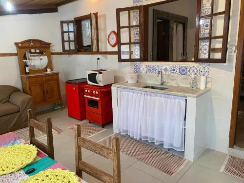eine Küche mit Spüle und Mikrowelle in der Unterkunft Casa COMPLETA, 2 quartos, Estacionamento GRATUITO, WIFI 300MB, frigobar, microondas, fogão e jardim in São João del Rei