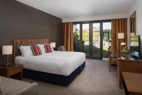 a hotel room with a large bed and a desk at Yarra Valley Lodge in Wonga Park