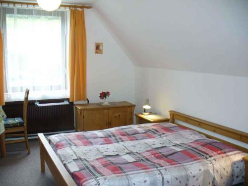 een slaapkamer met een bed, een stoel en een raam bij Apartment in Rokytnice nad Jizerou 2471 in Rokytnice nad Jizerou