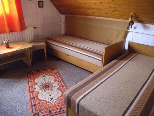 バダチョニトマイにあるHoliday home in Badacsonytomaj 20247のベッド2台、テーブル、ラグが備わる客室です。