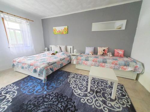 a bedroom with two beds and a rug at Dorci Vendégház - A piece of peace in Cserépfalu