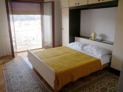 a bedroom with a large bed with a large window at Apartment in Kampor/Insel Rab 16142 in Kampor