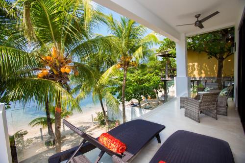 a balcony with a view of the beach and palm trees at Bella Luna Beach Condo #227473 in West End