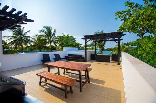 a patio with a wooden table and benches on it at Bella Luna Beach Condo #227462 in West End